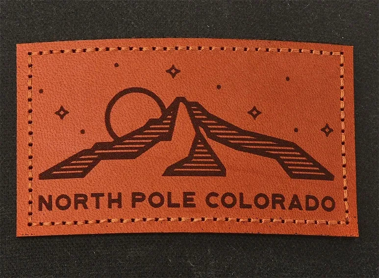 Chestnut etched leather patch reading North Pole Colorado