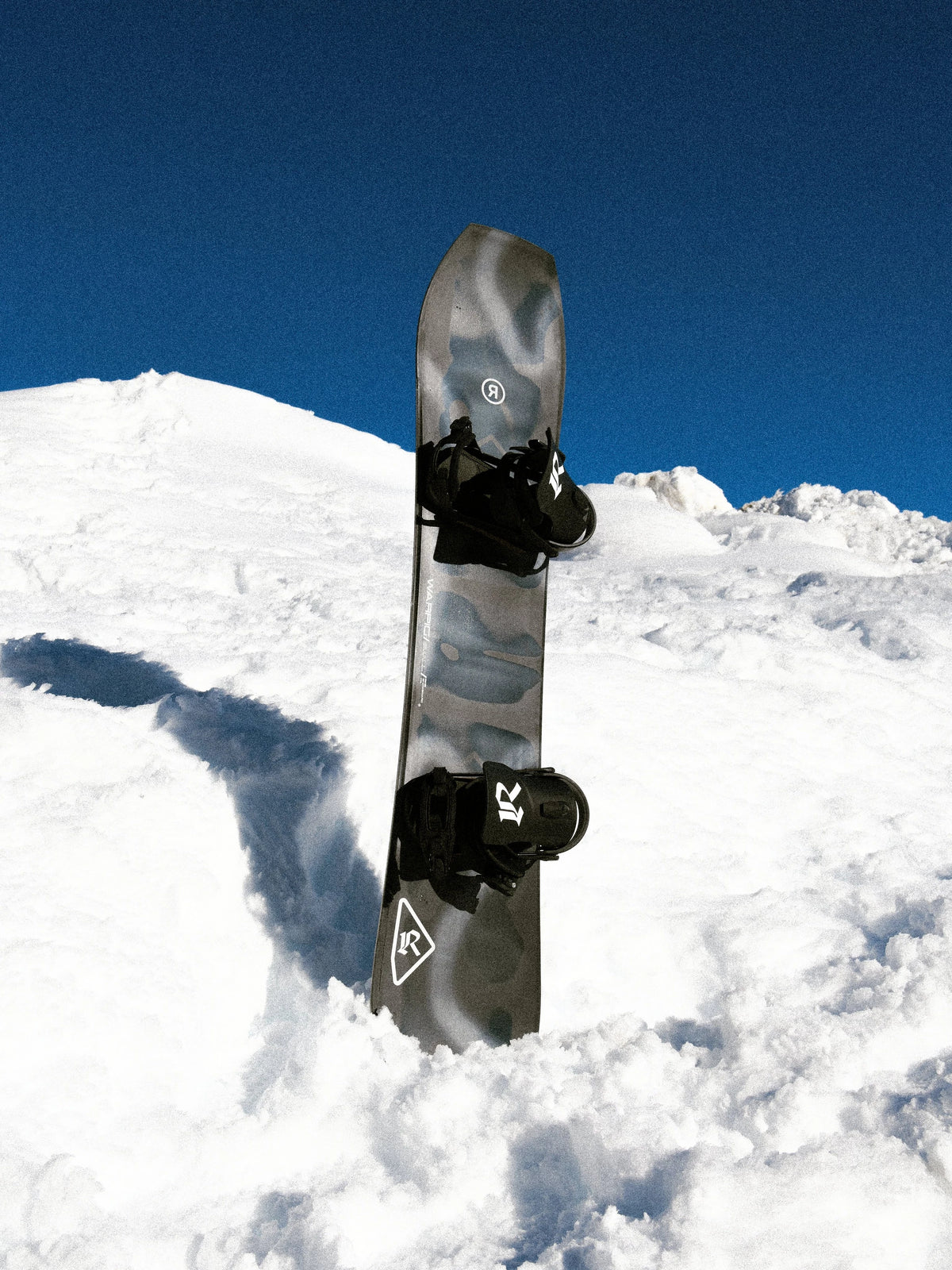 Ride Warpig Snowboard 2027 mounted with bindings in backcountry snow